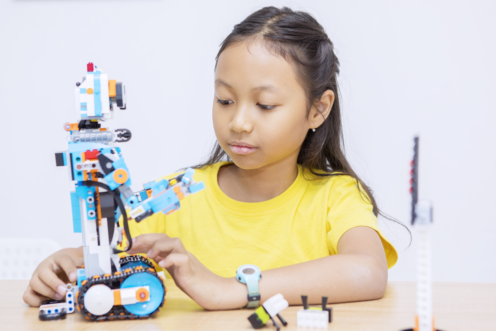 Portrait of Asian kid constructing a robot